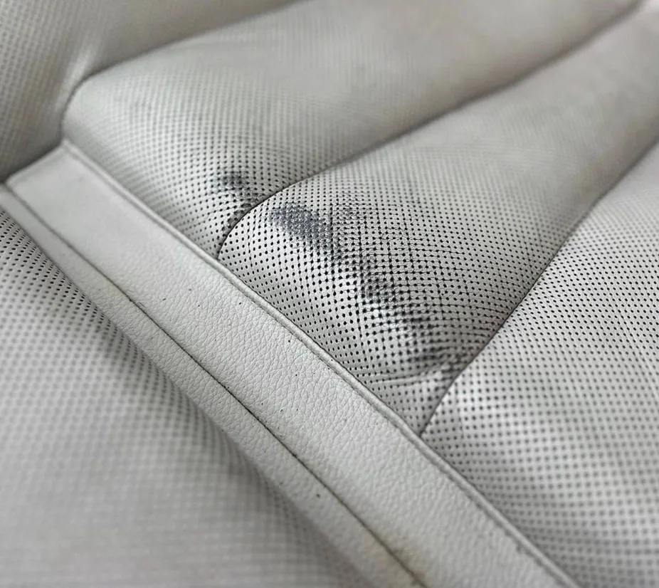 Before: cream perforated leather seat with dye transfer
