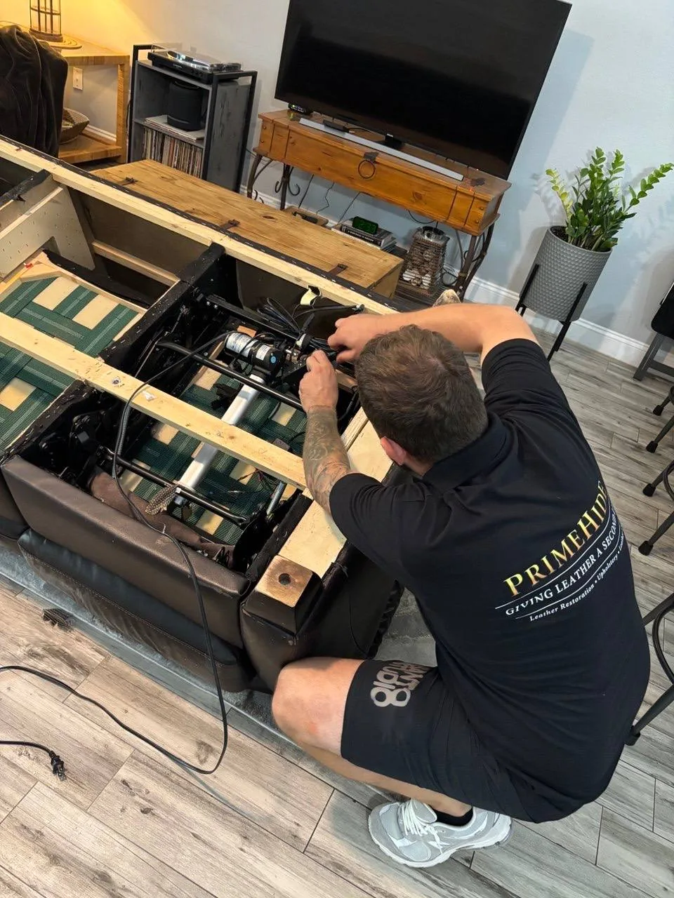 PrimeHide technician repairing a power sofa mechanism in a customer’s home